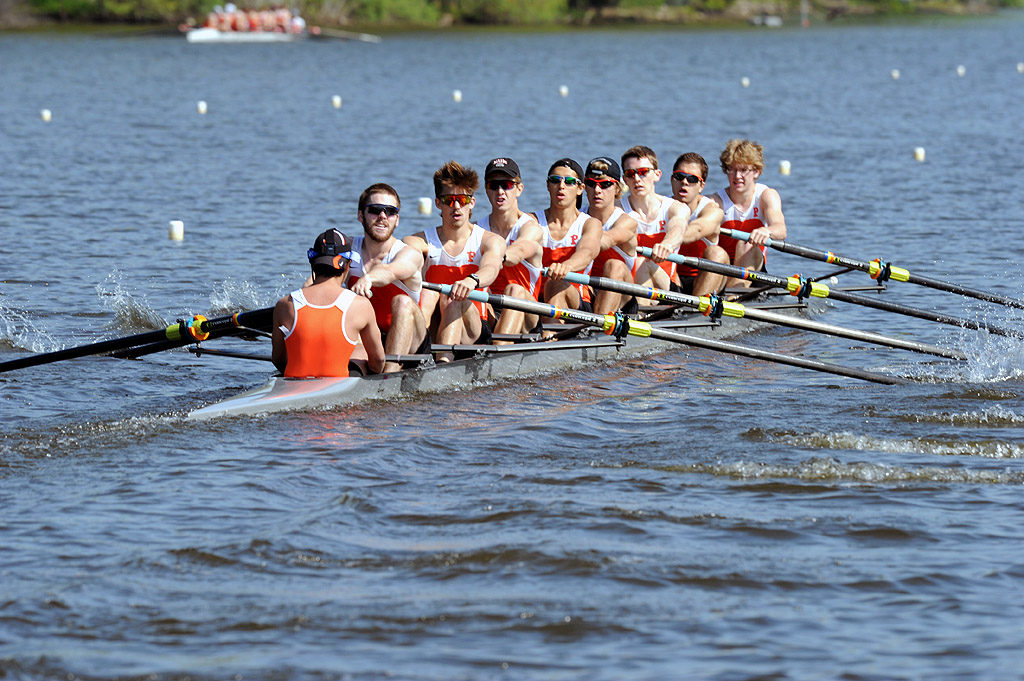 A group of people rowing a boat in a body of water