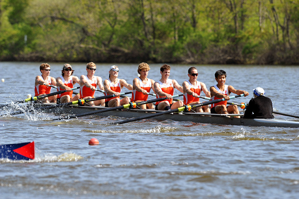 A group of people rowing a boat in a body of water