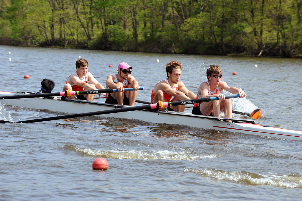 A group of people rowing a boat in a body of water