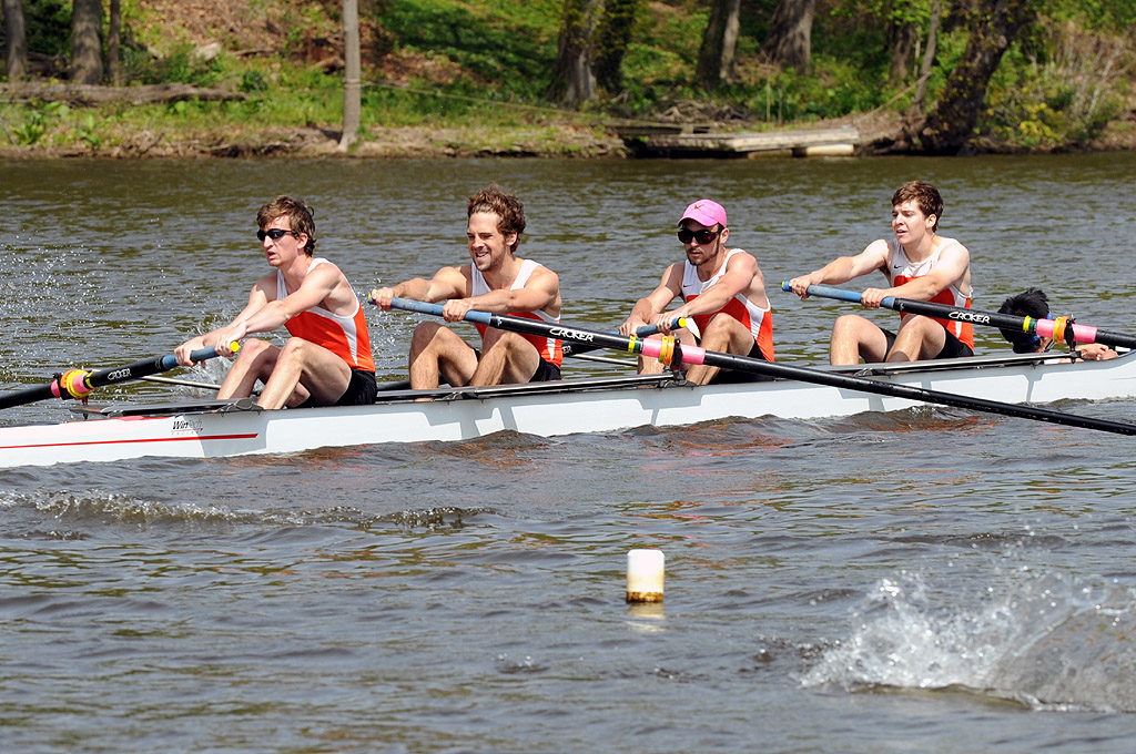 A group of people rowing a boat in a body of water