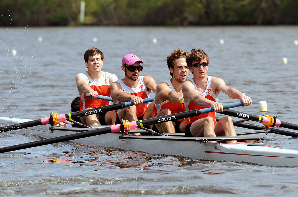 A group of people rowing a boat in a body of water