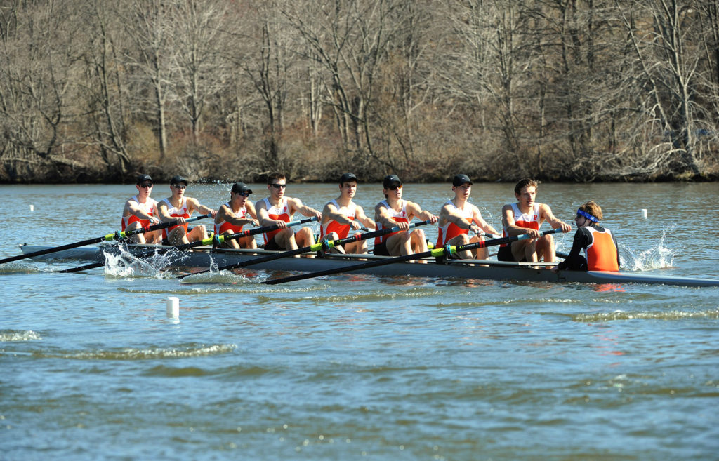 A group of people rowing a boat in a body of water