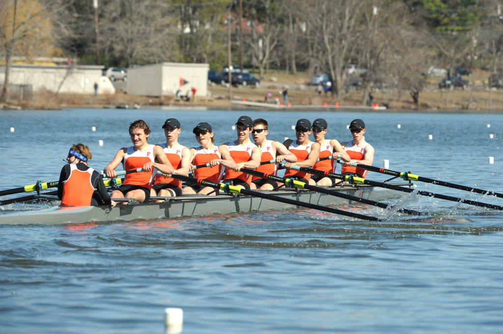 A group of people rowing a boat in the water