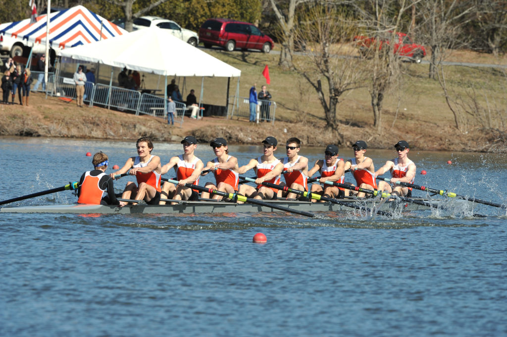 A group of people rowing a boat in the water