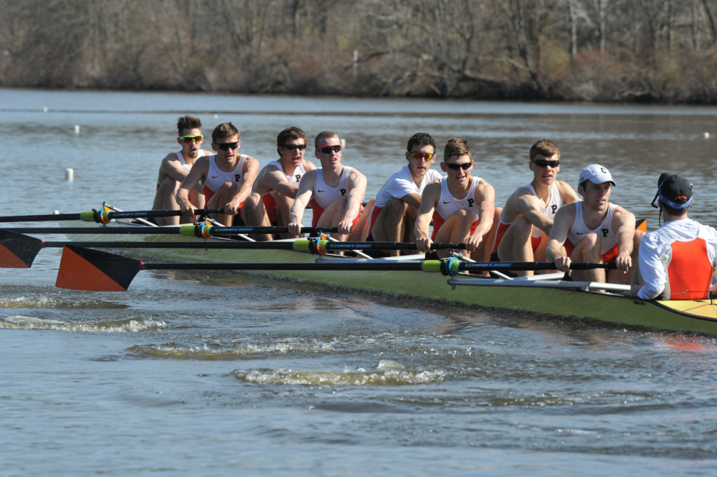 A group of people rowing a boat in the water