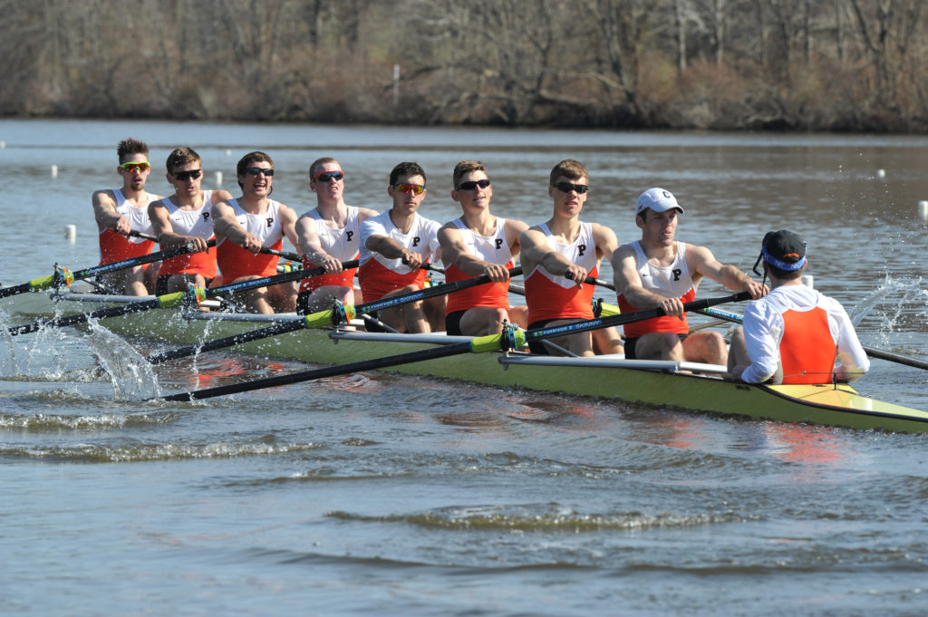 A group of people rowing a boat in the water