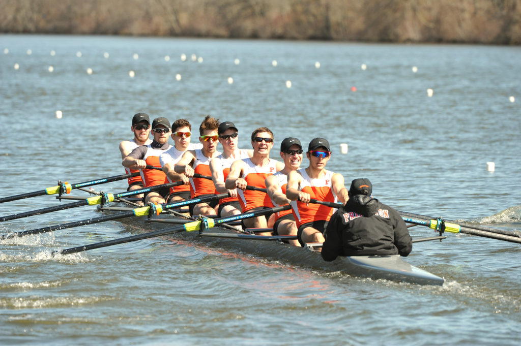 A group of people rowing a boat in a body of water