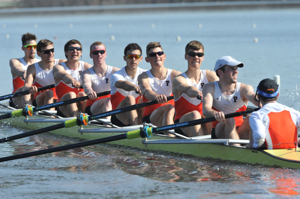 A group of people rowing a boat in the water