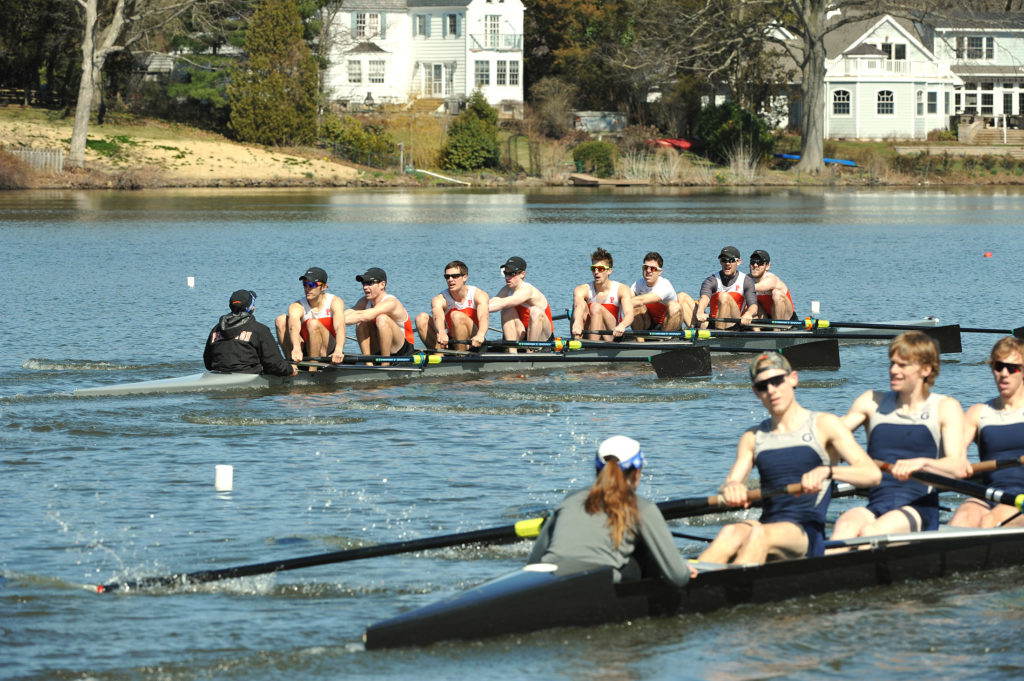 A group of people rowing a boat in the water