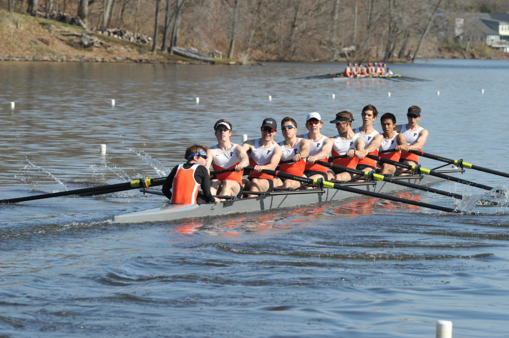 A group of people rowing a boat in the water