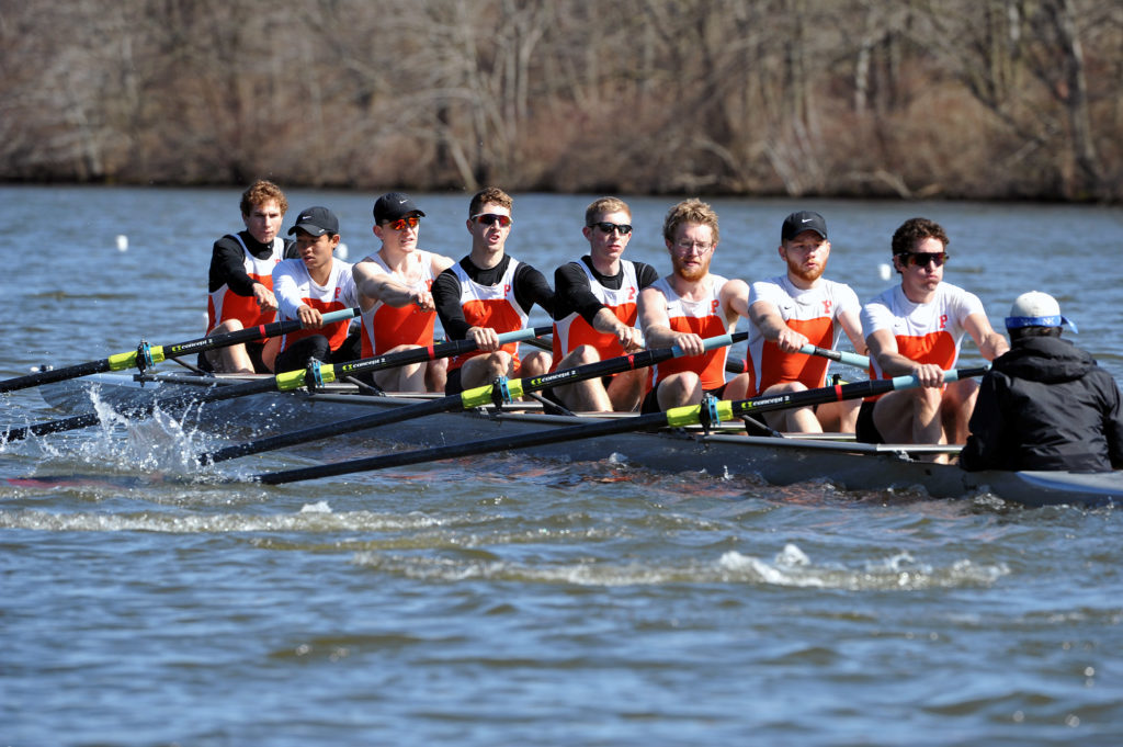 A group of people rowing a boat in the water