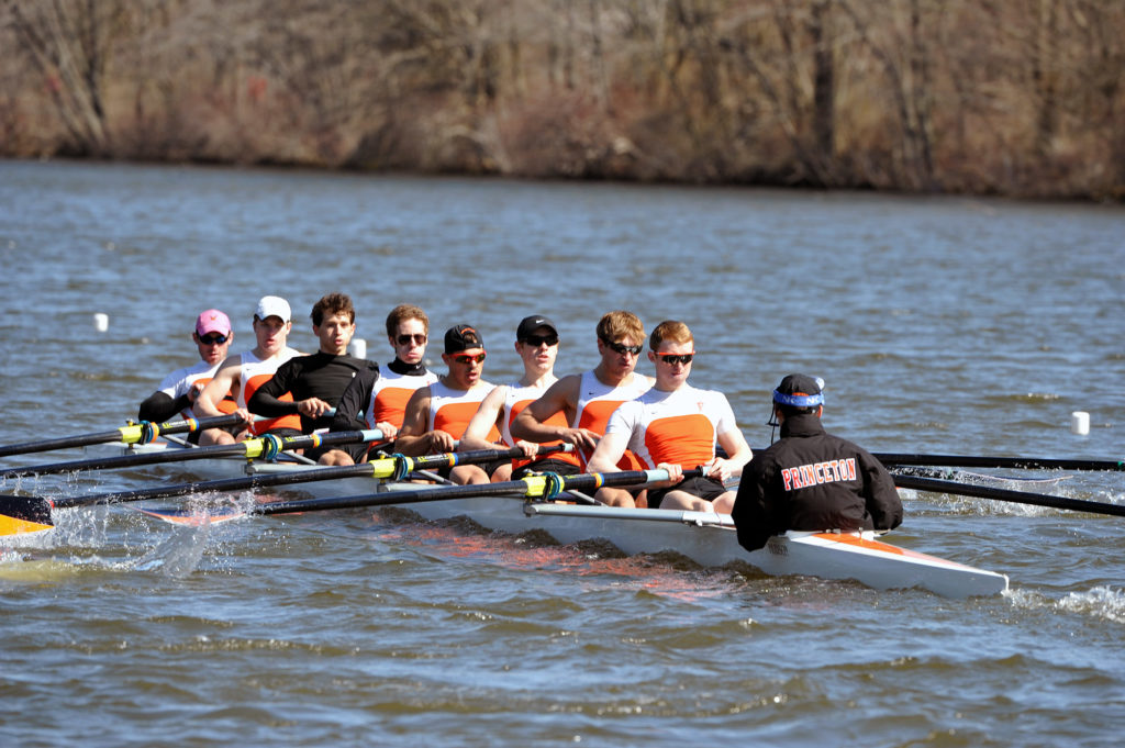 A group of people rowing a boat in a body of water