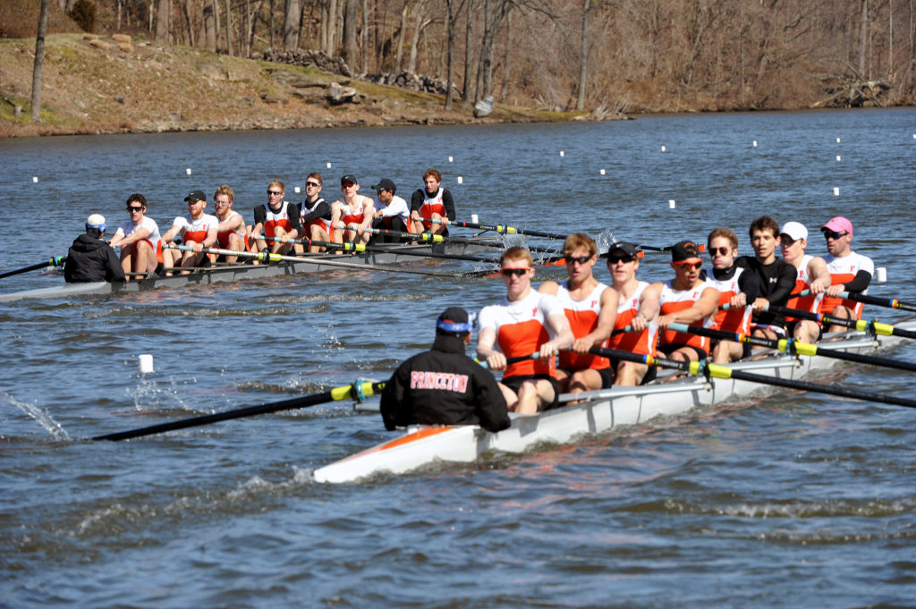 A group of people rowing a boat in a body of water