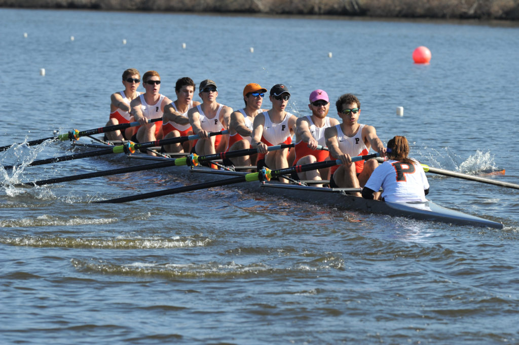 A group of people rowing a boat in a body of water