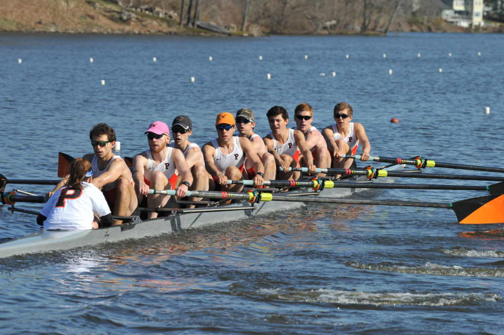 A group of people rowing a boat in a body of water