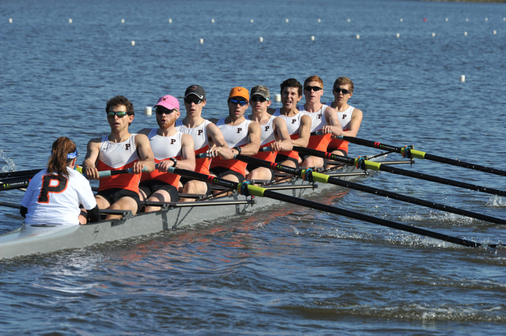 A group of people rowing a boat in a body of water