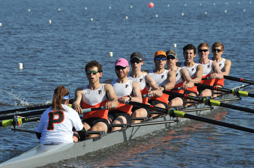 A group of people rowing a boat in a body of water