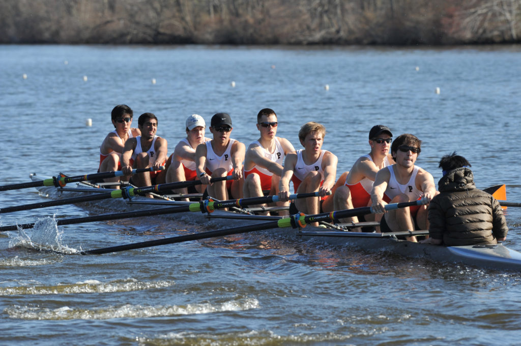 A group of people rowing a boat in a body of water