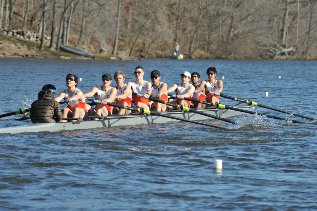 A group of people rowing a boat in a body of water