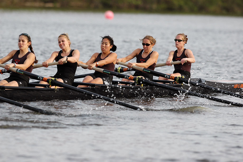 A group of people rowing a boat in the water