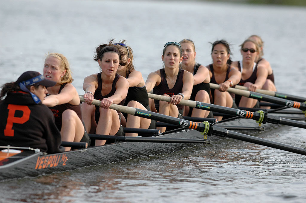 A group of people rowing a boat in the water