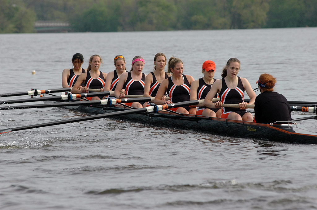 A group of people rowing a boat in a body of water