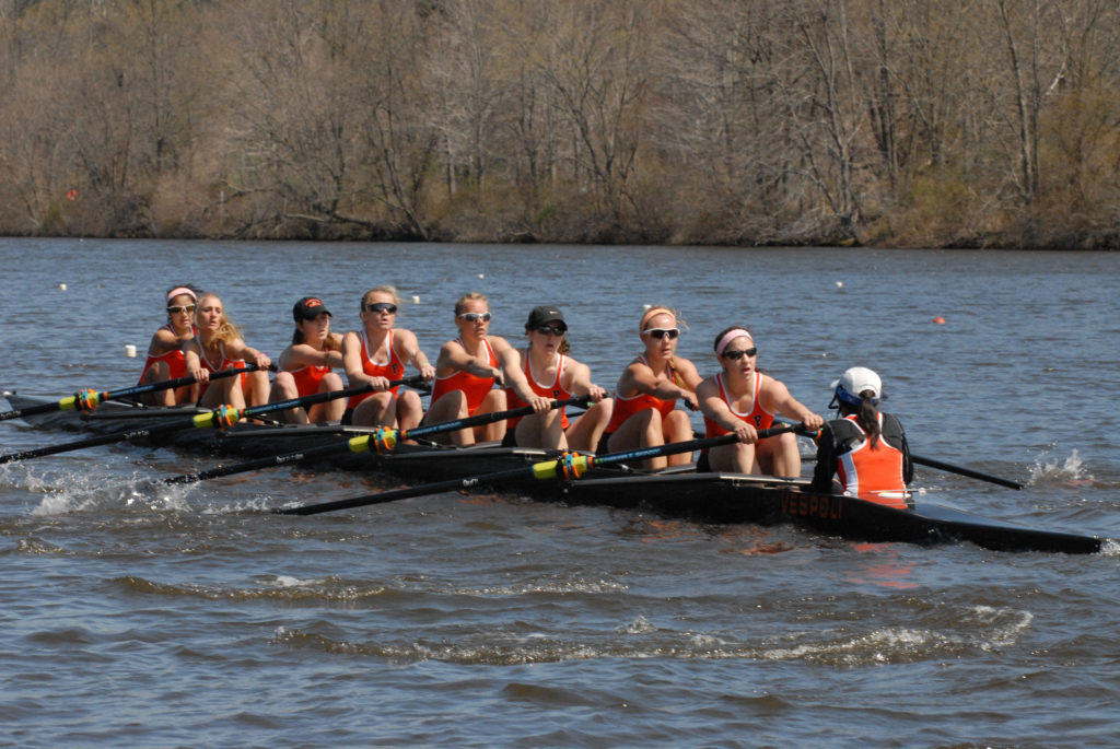 A group of people rowing a boat in the water