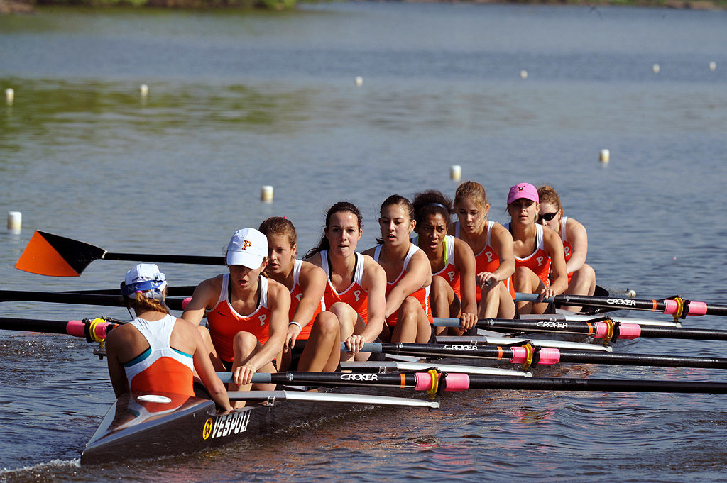 A group of people rowing a boat in a body of water