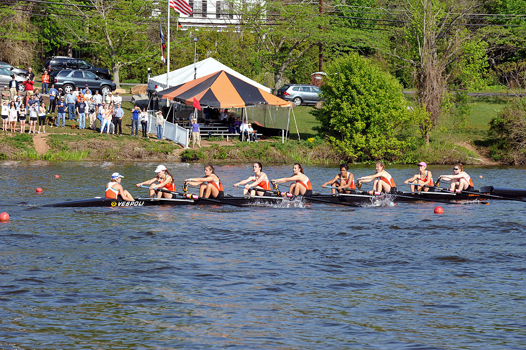 A group of people rowing a boat in a body of water