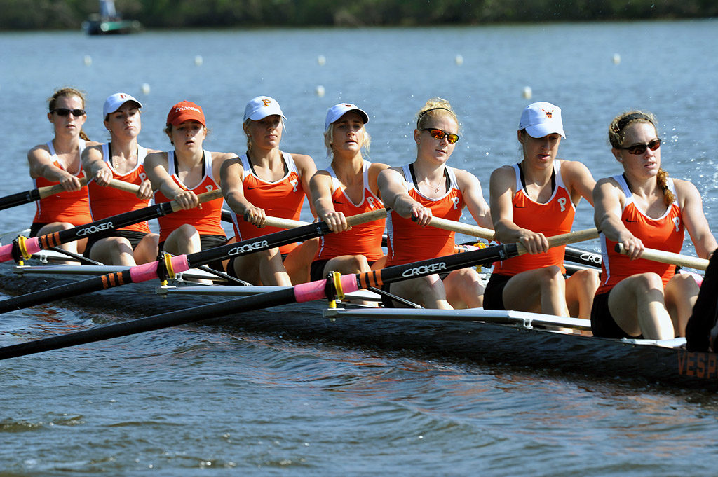 A group of people rowing a boat in the water