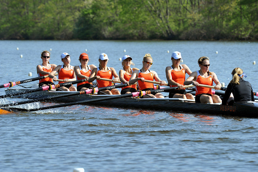 A group of people rowing a boat in a body of water