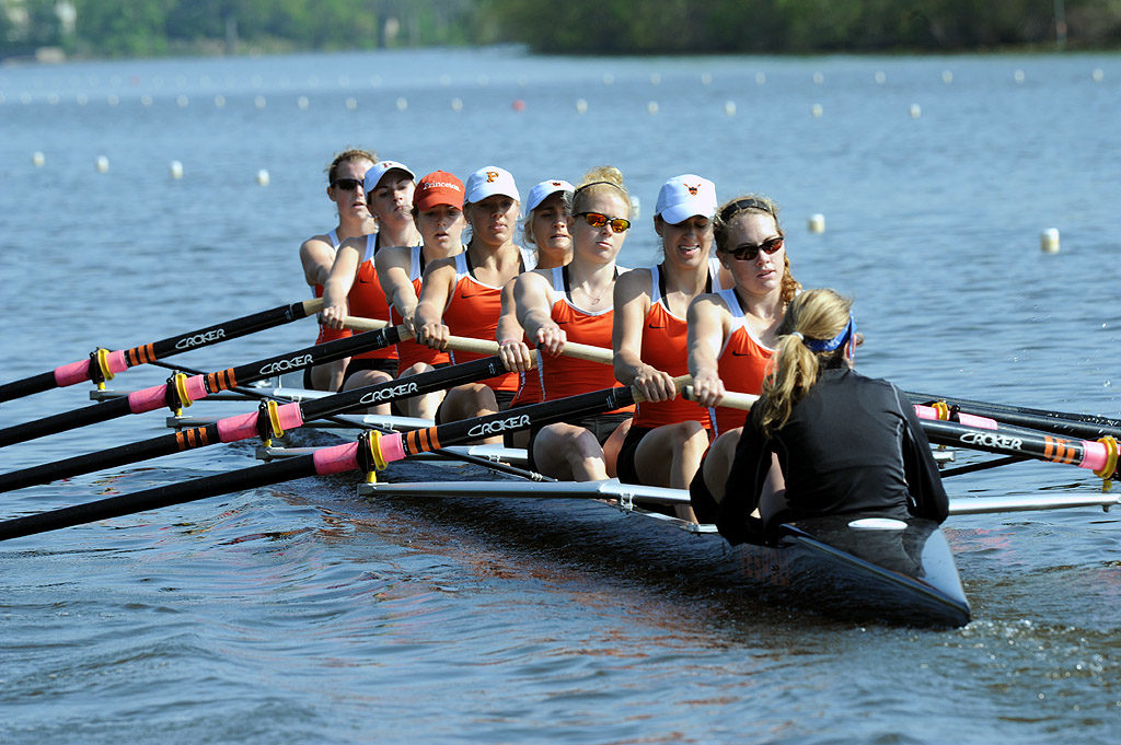 A group of people rowing a boat in a body of water