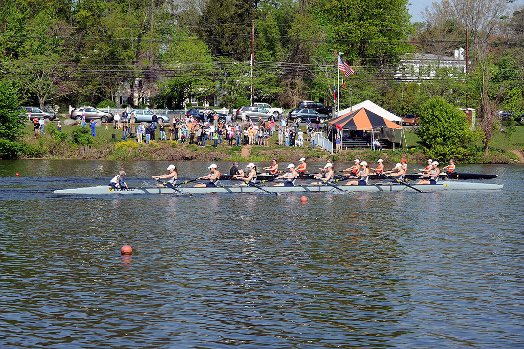 A group of people rowing a boat in a body of water