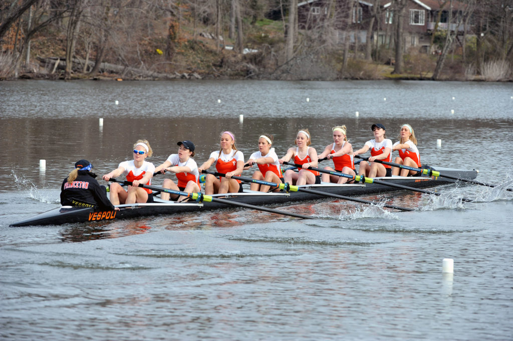 A group of people rowing a boat in the water