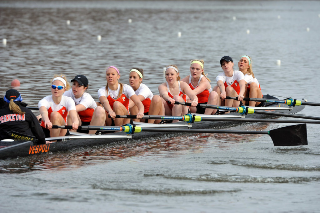 A group of people rowing a boat in the water