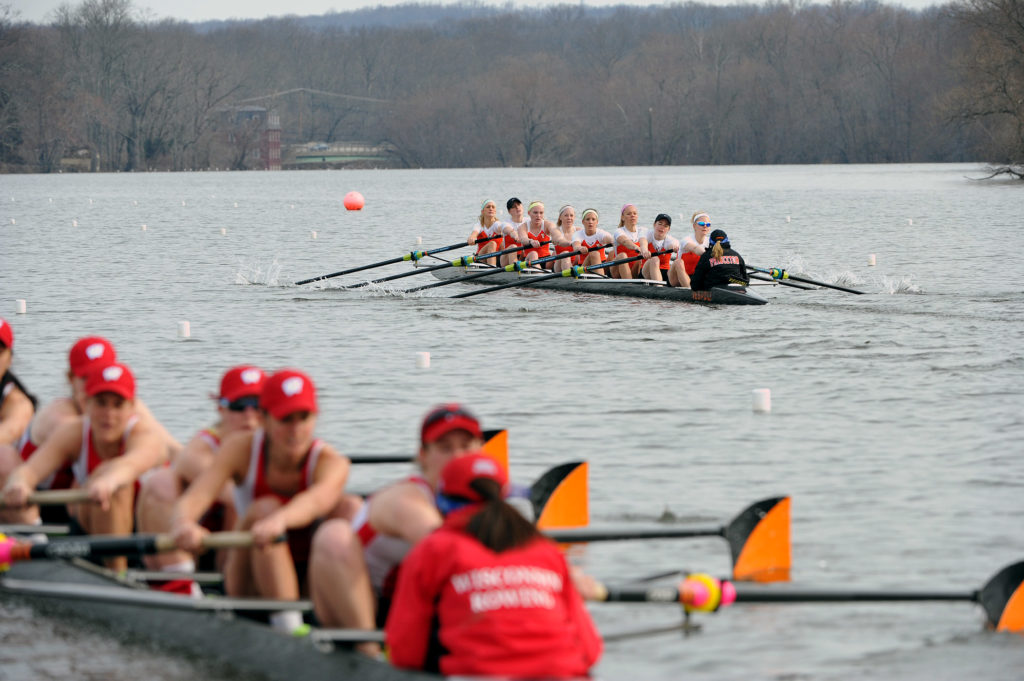 A group of people rowing a boat in the water