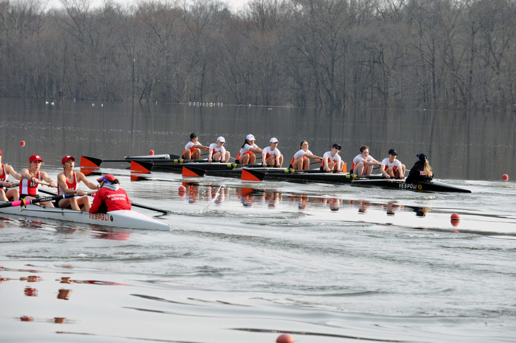 A group of people rowing a boat in the water