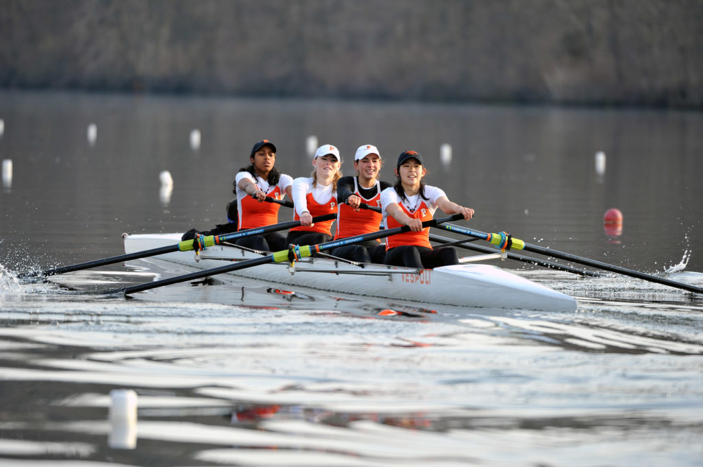 A group of people rowing a boat in the water