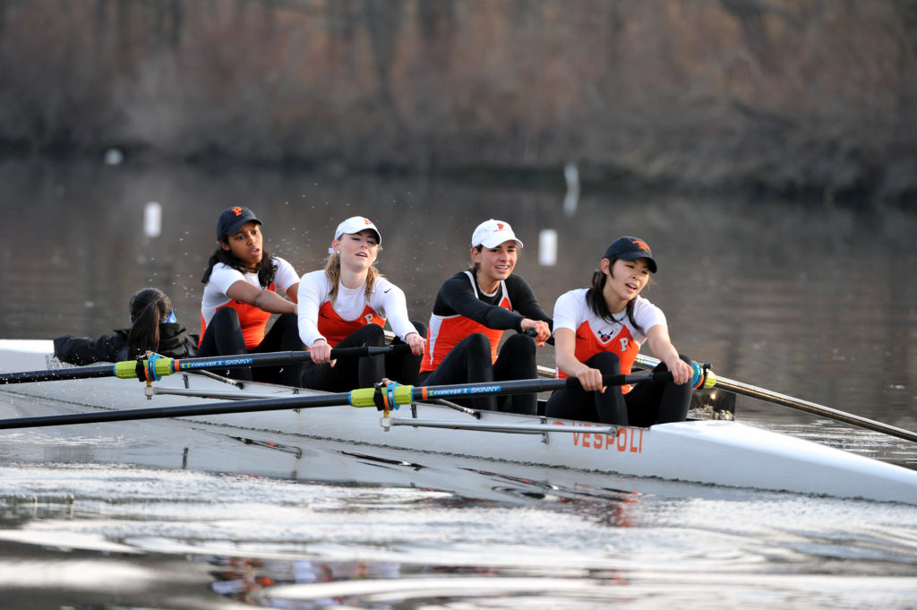 A group of people rowing a boat in the water