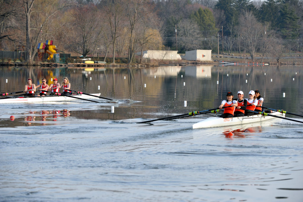 A group of people rowing a boat in the water