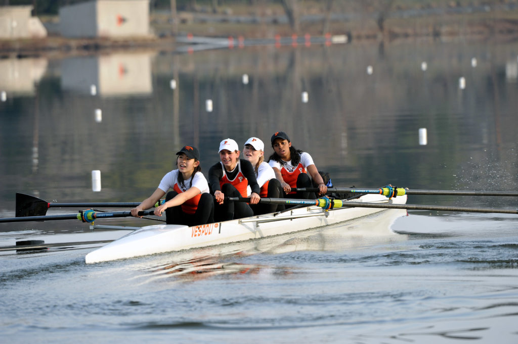 A group of people rowing a boat in the water