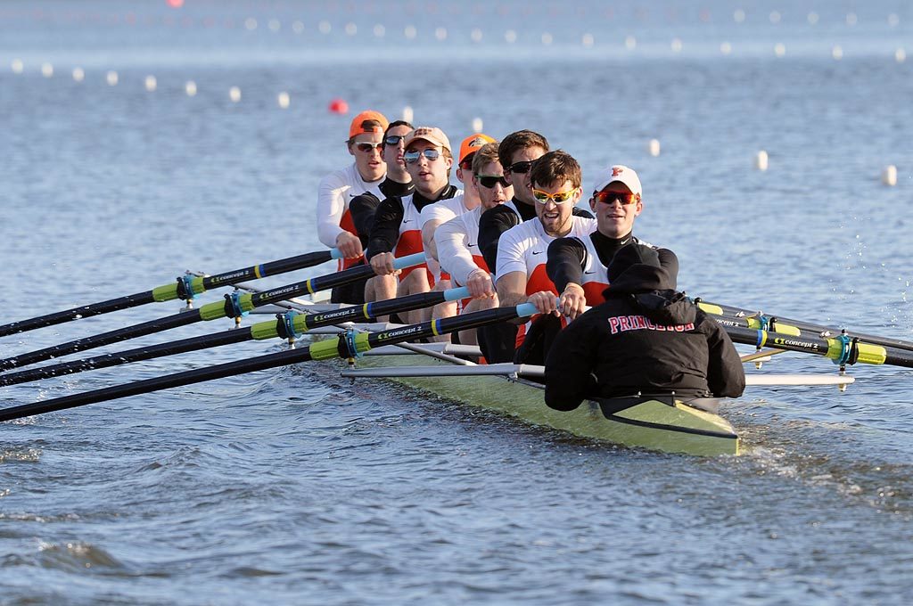 A group of people rowing a boat in a body of water