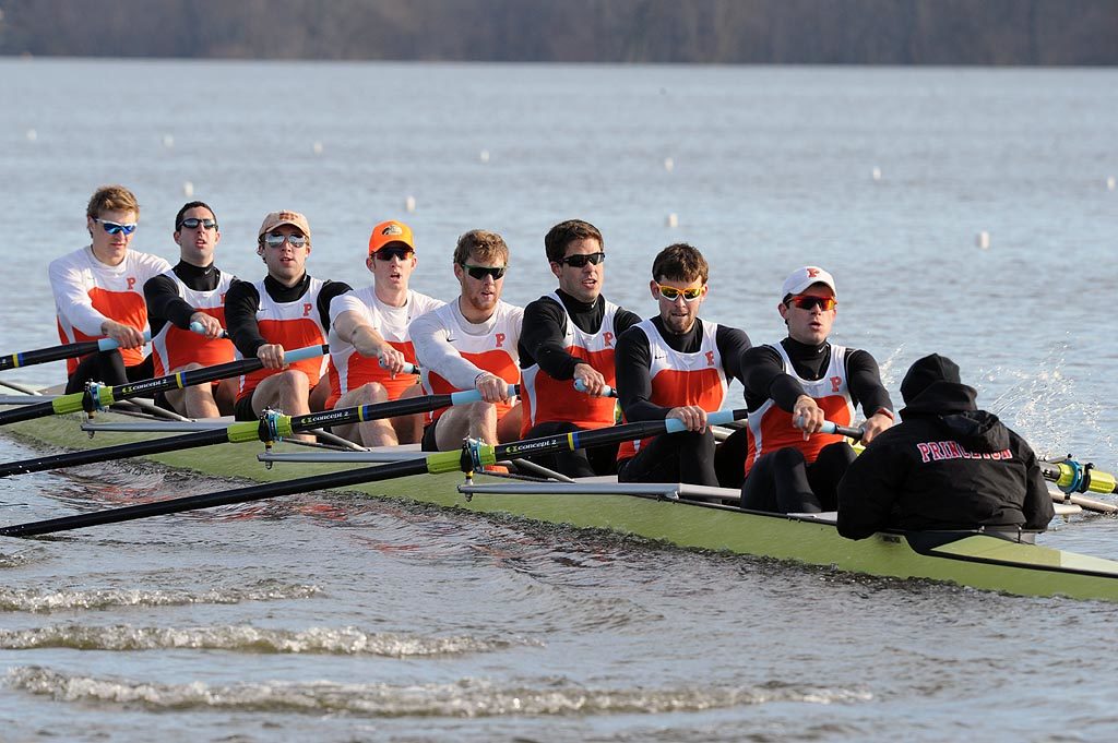 A group of people rowing a boat in the water