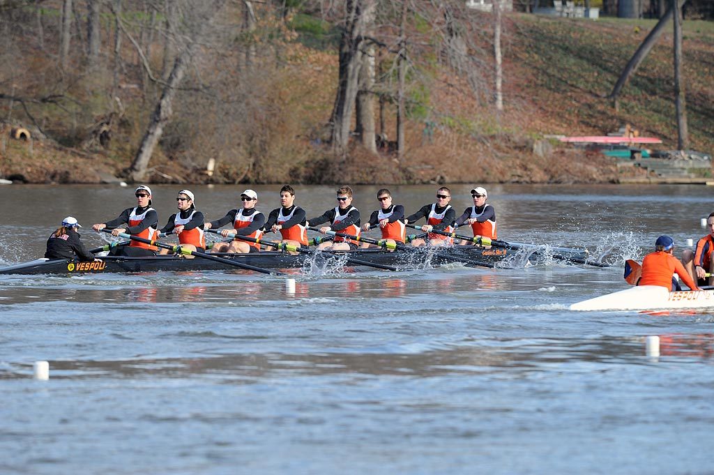 A group of people rowing a boat in a body of water