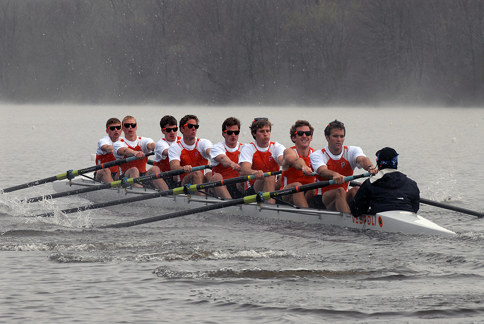 A group of people rowing a boat in the water