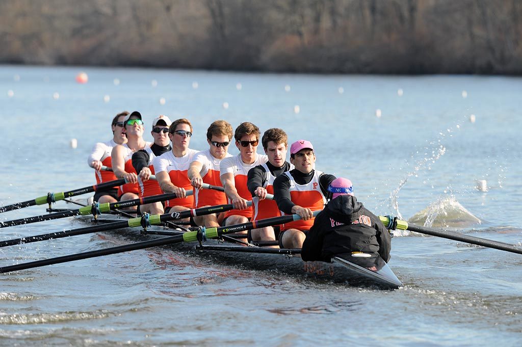 A group of people rowing a boat in the water