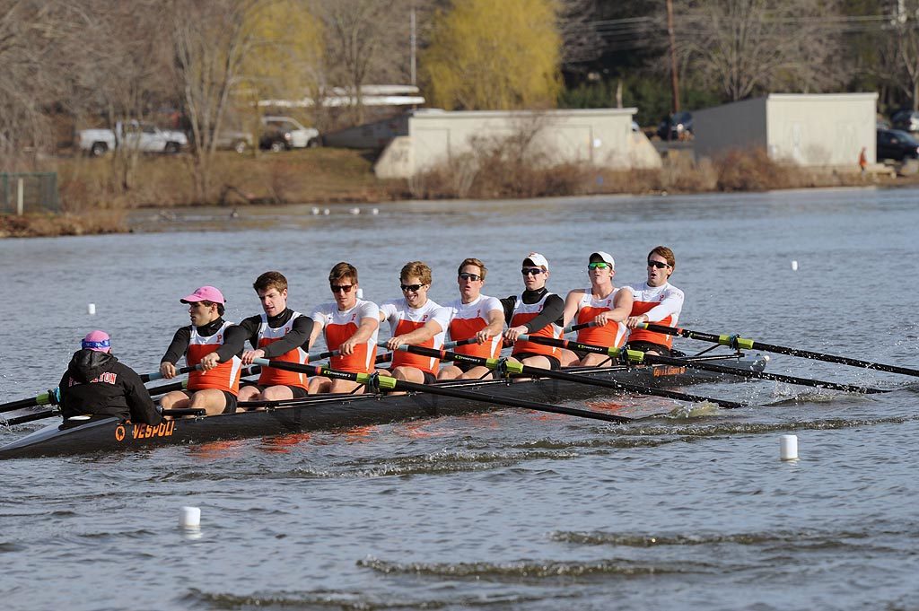 A group of people rowing a boat in the water