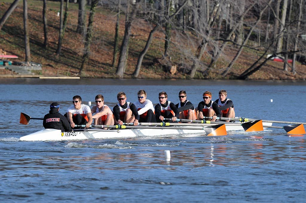 A group of people rowing a boat in the water