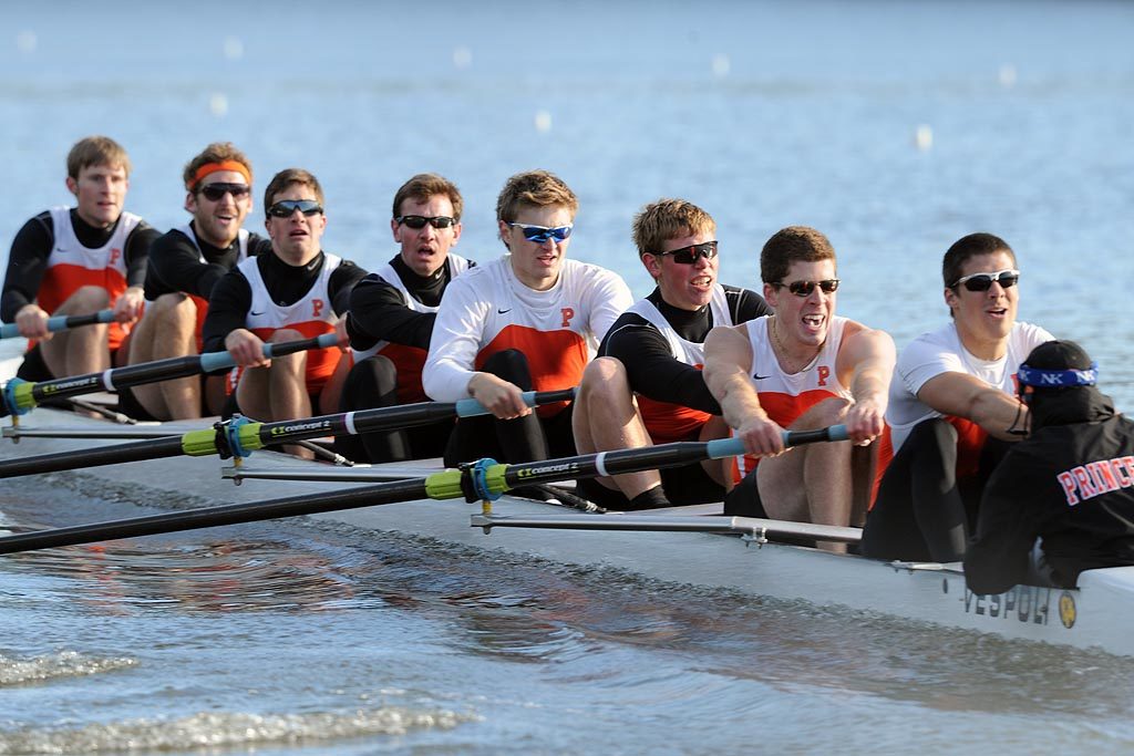 A group of people rowing a boat in the water