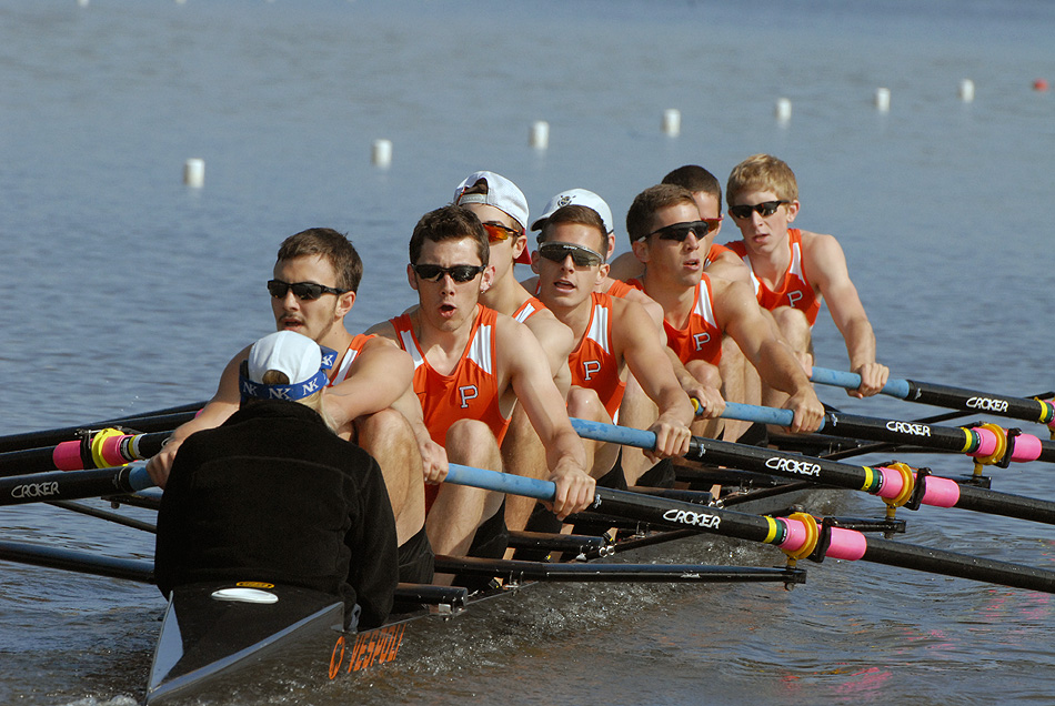 A group of people rowing a boat in the water